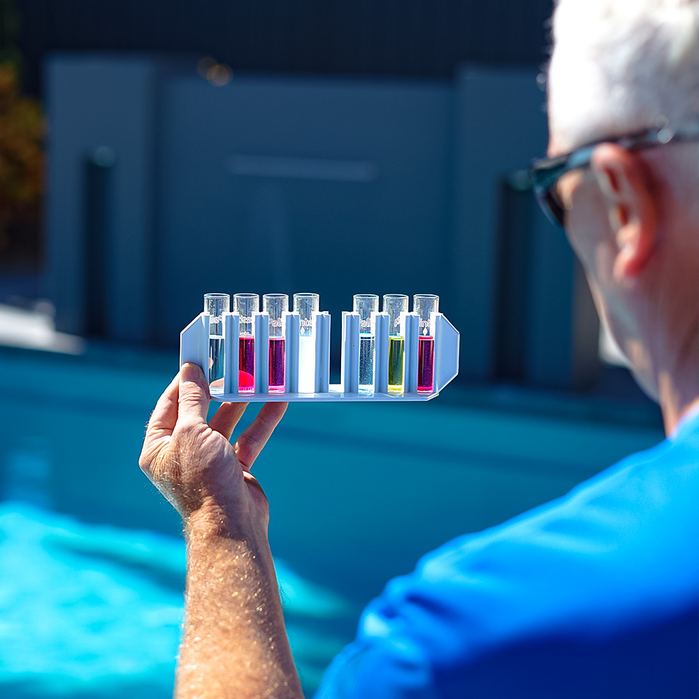 HowToShockYourPool_Thumb-watertest a pool technician testing chlorine levels in the pool to determine whether he needs to do a pool shock