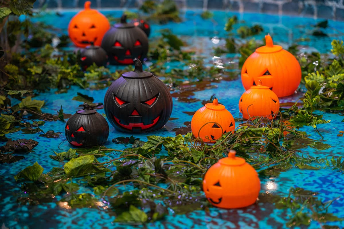 Group of orange and black Halloween jack o lantern Halloween swimming pool party decorating idea