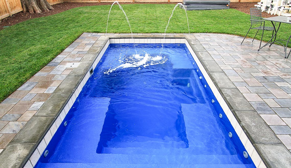 Leisure Pools Palladium Plunge fiberglass swimming pool with wrapped bench area
