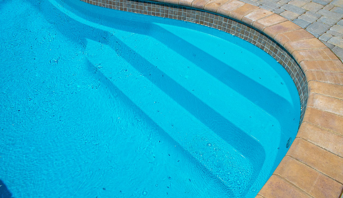Leisure Pools Tuscany freeform fiberglass swimming pool with spacious entry and exit steps