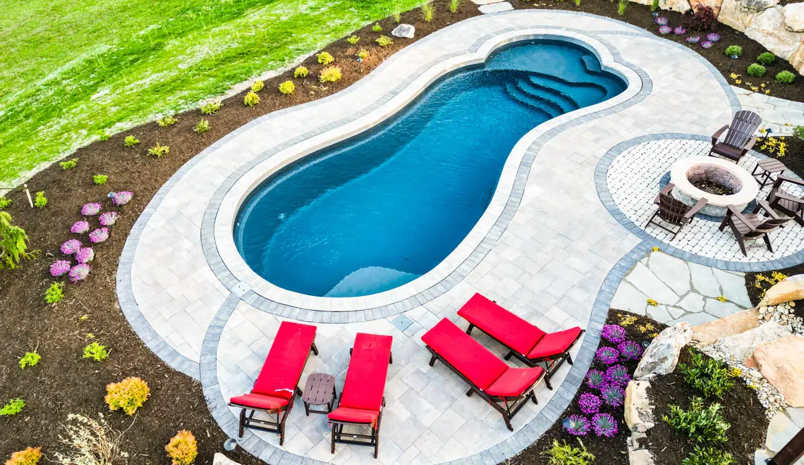 Leisure Pools Eclipse freeform fiberglass swimming pool with built-in splash deck