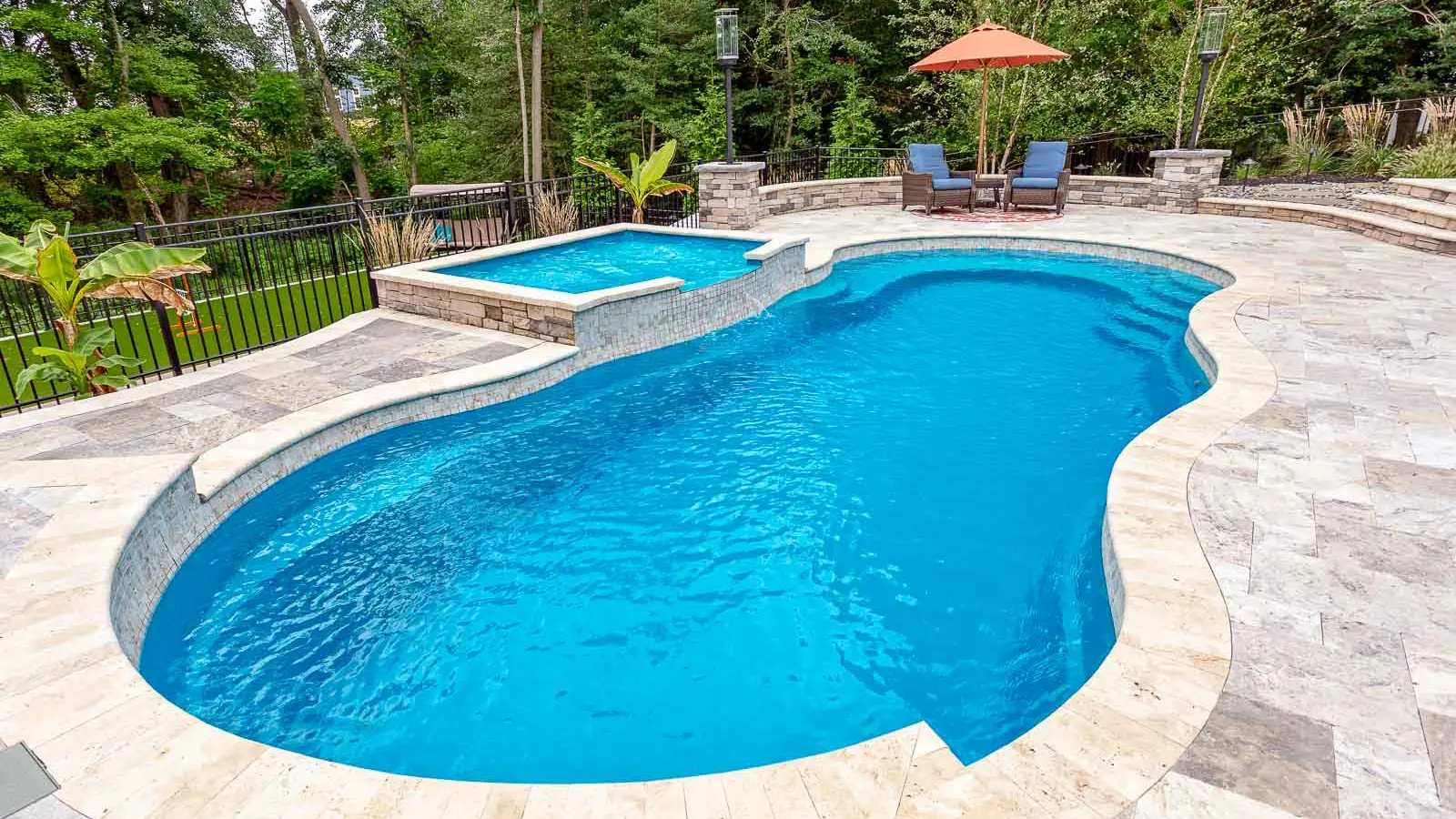 Leisure-Pools-Riviera-fiberglass-pool The Riviera, a freeform fiberglass pool with a wraparound entry step/ seating area and seating in the deep end