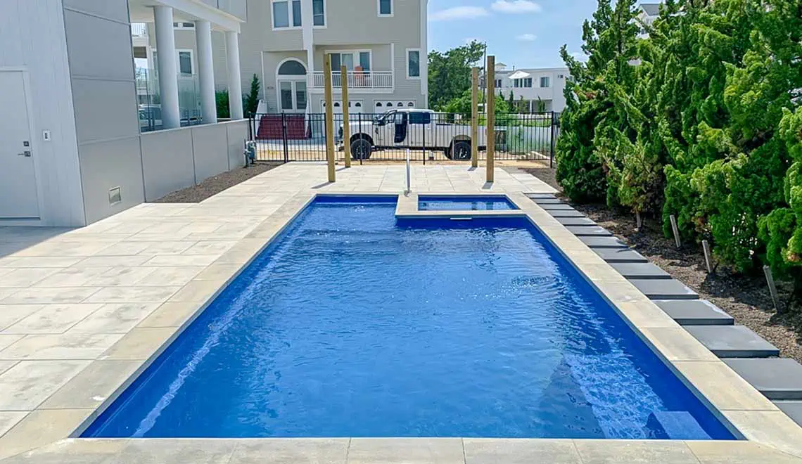 Leisure Pools Limitless fiberglass pool shape with built-in spa and splash deck