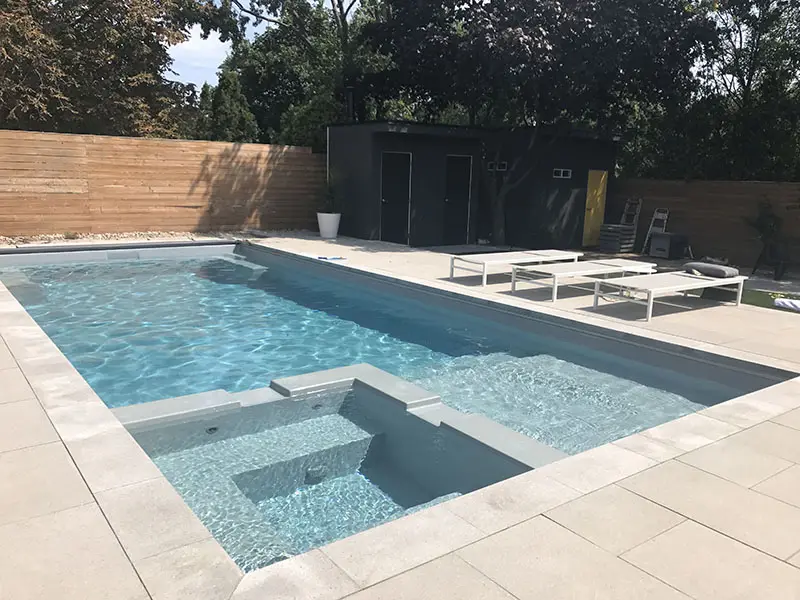 Leisure Pools Limitless fiberglass inground swimming pool features a splash pad